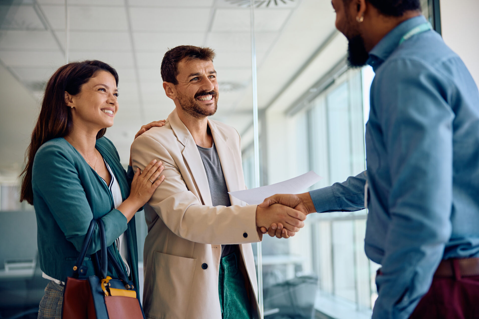Happy couple handshaking with their financial advisor in the office. happy couple handshaking with their financial advi 2024 01 12 16 47 59 utc