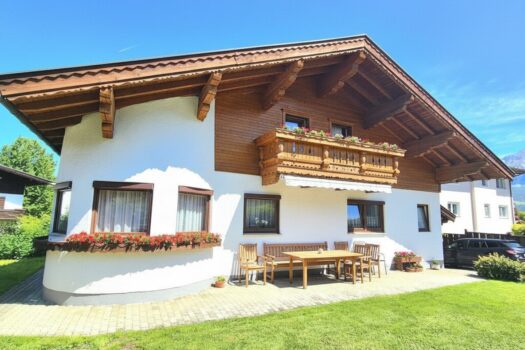 Gepflegtes leistbares Familienhaus in Dorfrandlage . Außenansicht Holzelemente mit KI aufgehellt