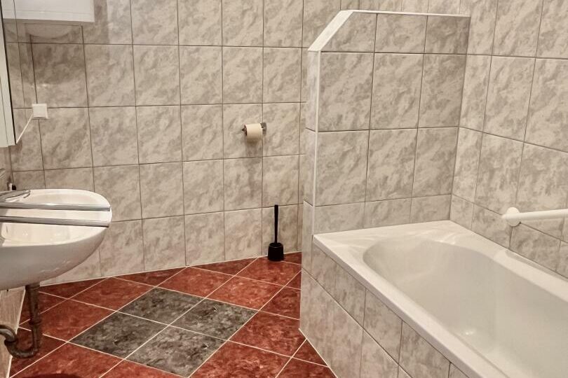 Badezimmer mit Wanne und WC (abgetrennt)