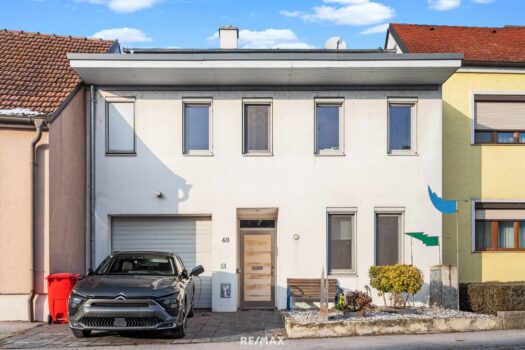 Straßenansicht mit Abstellplatz und E-Ladestation