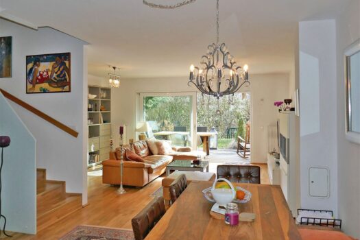 Wohnzimmer mit offener Küche und Ausgang auf die Gartenterrasse